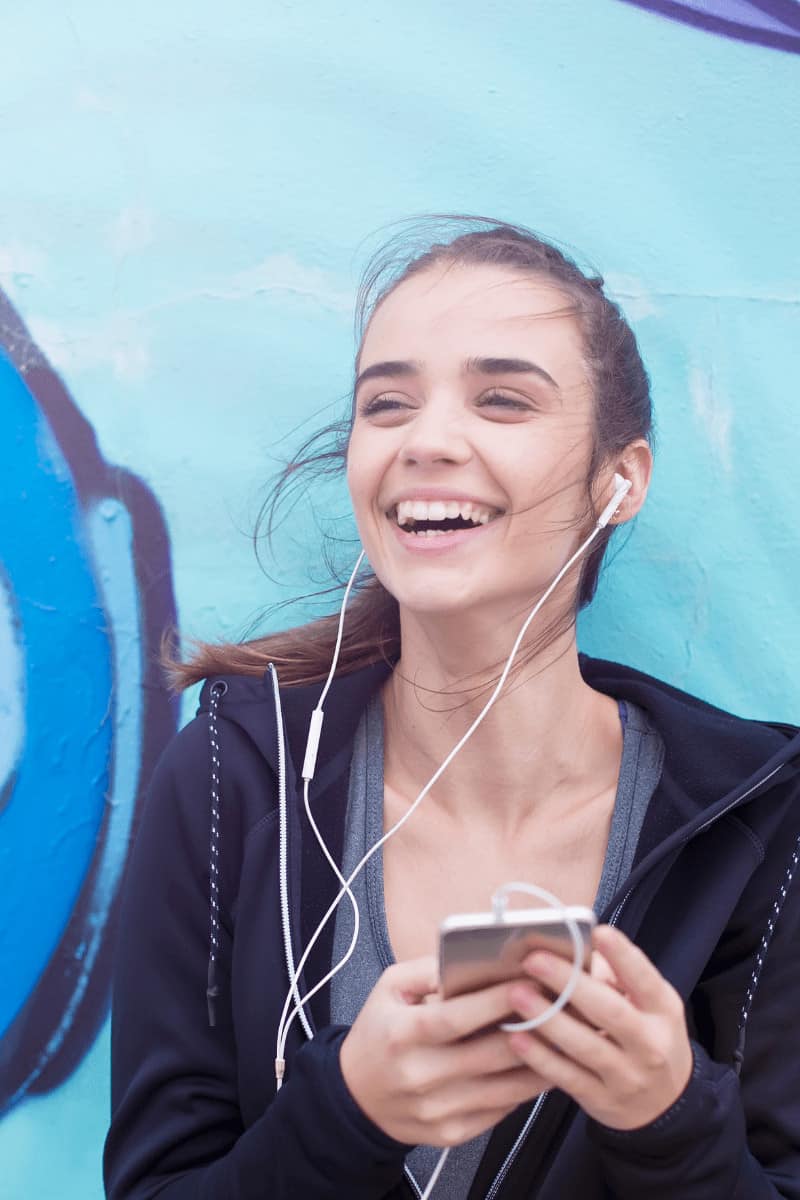 female-phone-habit young female smiling with phone in hand
