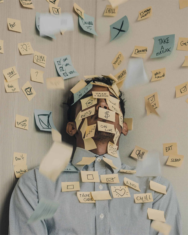 Man covered in post-it reminders of various household tasks for which he lacks motivation.