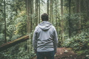 Man in forest contemplating path forward